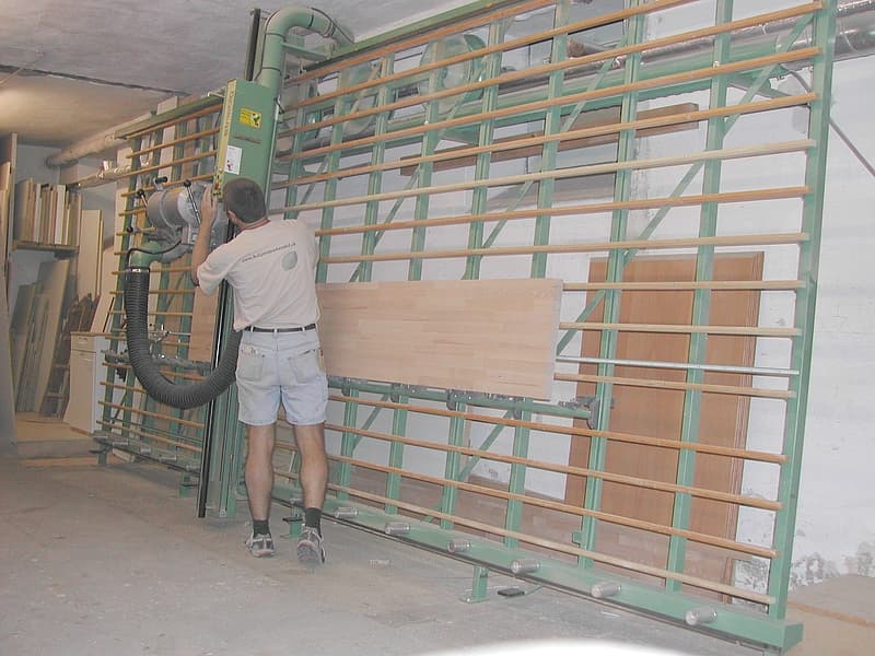 Zuschnitt einer Holzplatte auf der Plattensäge in der Werkstatt